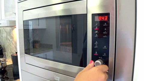 Female hands  using microwave oven