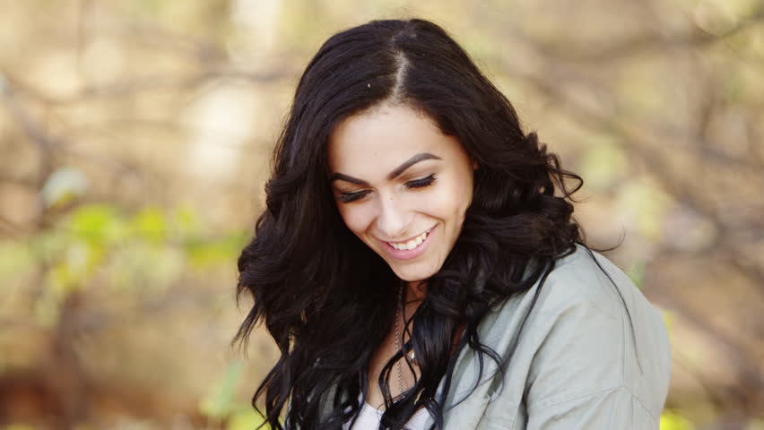 Leaves falling from the sky, brunnete woman laughing.