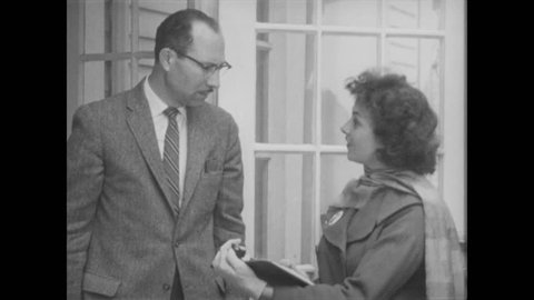 1960s: Woman speaks to resident, referencing her clipboard. Man homeowner talks with her.