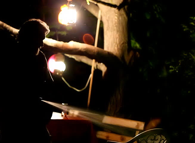 Senior man holding a hose at night time 
