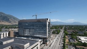 Construction of new big glass building in a city with mountains.