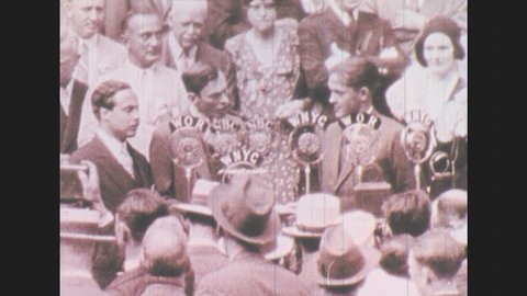 1930s: Mayor of New York makes speech into radio microphones next to honorary golf player, Bobby Jones before crowd. People clap.