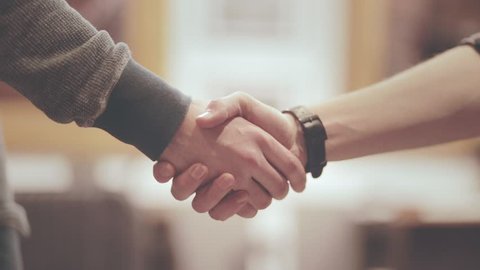 Handshake of two men. Friendly man shaking hands. Close up of men greeting with handshake. Business partners handshaking