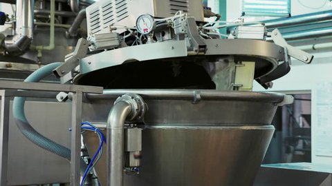 The process of heating milk in a pasteurization tank. Dairy factory. Line production of dairy products