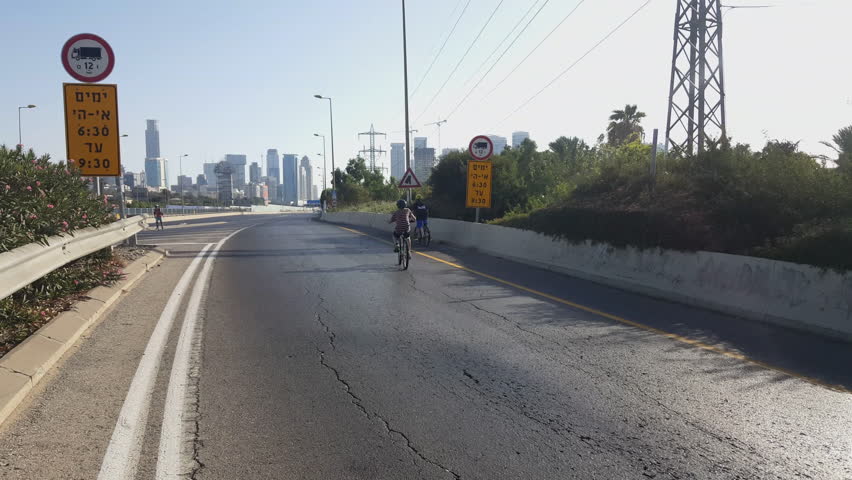 Children cycle on highway ramp, Yom Kippur, Ayalon highway, Tel-Aviv high rises