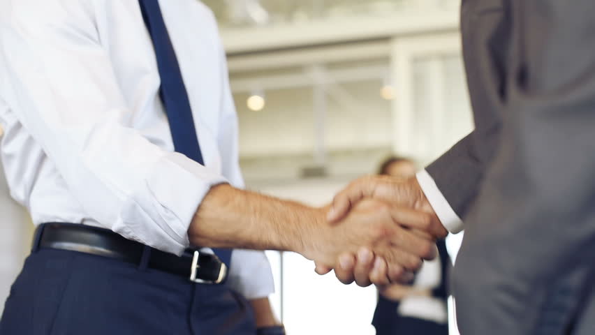 Businessmen shaking hands during a meeting. Closeup of business handshake between two colleagues in a modern office. Successful businessmen handshaking closing a deal. Agreement and business concept.