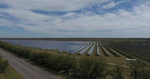 Aerial view above many photovoltaic panels large renewable green energy solar farm near the road