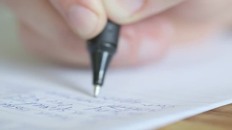 Extreme close up of a pen writing exam essay or letter, shallow depth of field.