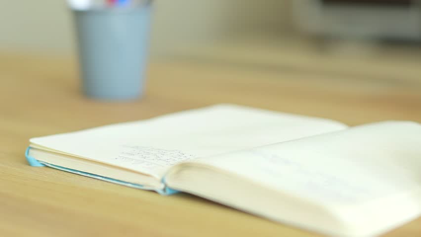 Man in a checked shirt writing a to do list in a notebook, shallow depth of field. Royalty-Free Stock Footage #30983854