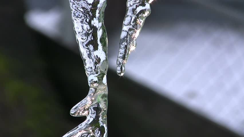 Camera tilt of a closeup of an icicle with sun shining through it