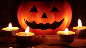Halloween pumpkin decoration and candle light closeup in dark night blur background