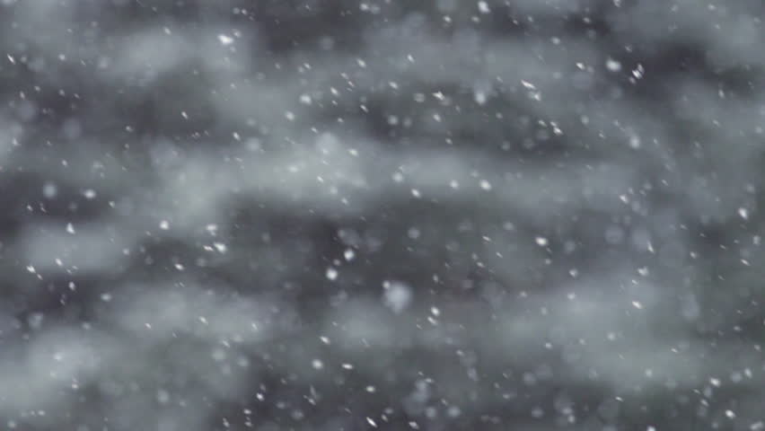 Snow falling in slow motion, flakes swirling and drifting against a backdrop of