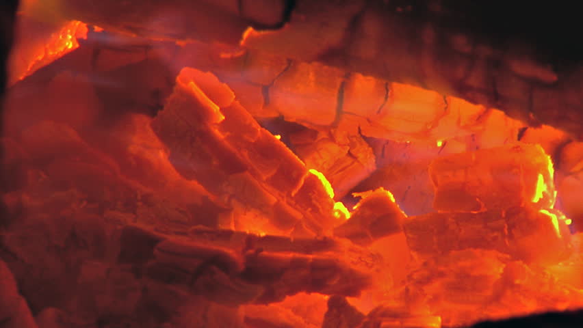Close up of embers flickering with flames.