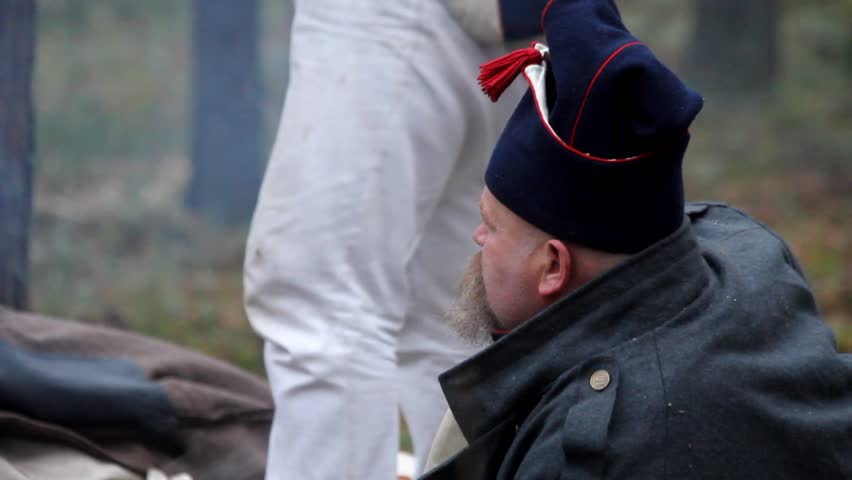 A soldier of the French army lies in the forest by the fire, reconstruction of the war of 1812, the retreat of Napoleon