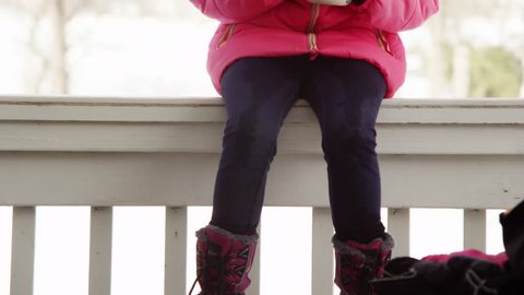 Little girl drinking hot chocolate outdoors, winter day.