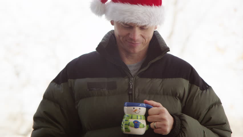 Man drinking hot beverage outddors, winter day.