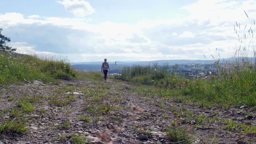 Young girl is walking along the path
