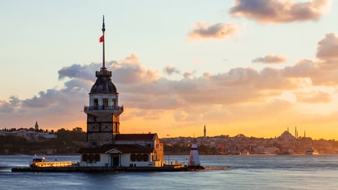 Timelapse of Maiden Tower or Kiz Kulesi with floating tourist boats on Bosphorus in Istanbul at sunset
