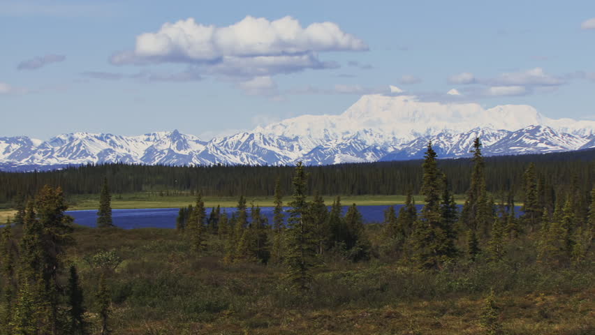 Time lapse of clouds over Denali (Mt. McKinley) in Alaska over a pristine mountain lake in the spruce taiga.
