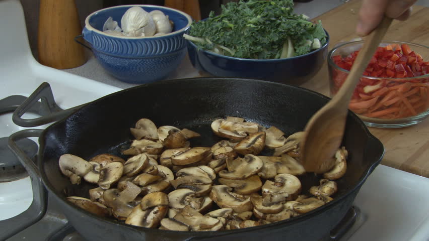 Preparing food - cooking sliced mushrooms