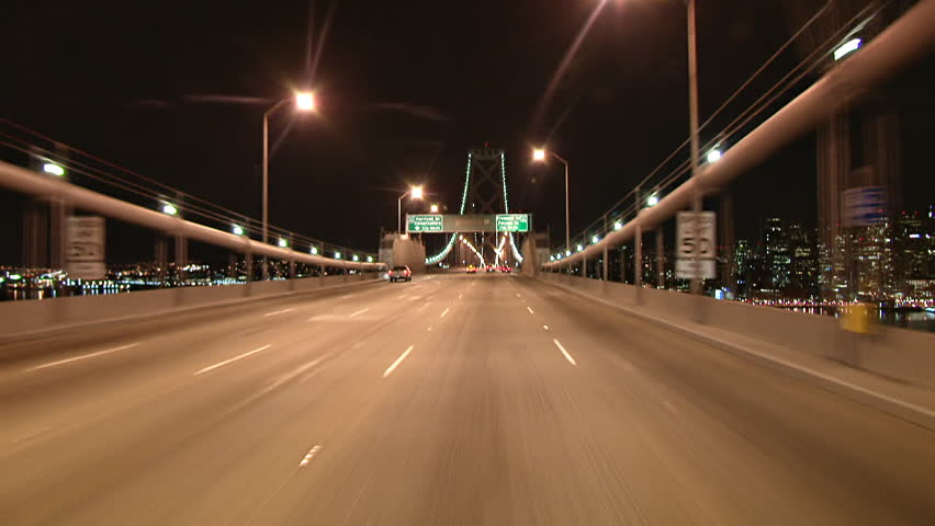 The lights of San Francisco twinkle in the night as this POV shot, crossing the