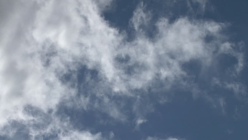 Tendrils of big puffy clouds in a blue sky.