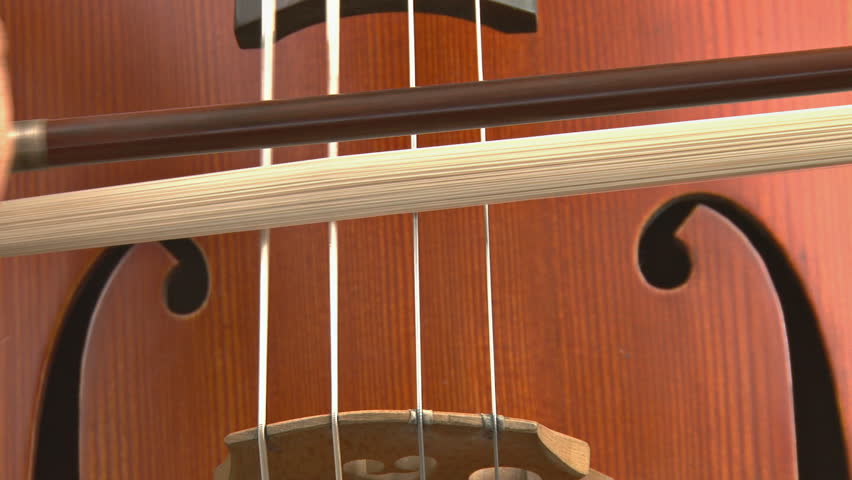 playing long tones and bowing slowly on a cello. Close shot.