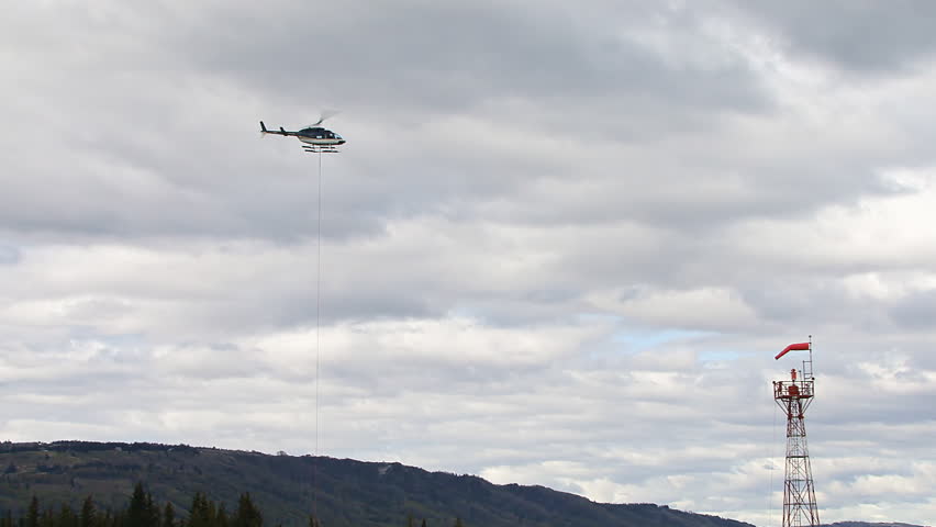 Helicopter with barrel in barrel sling suspended by a long line (longline)