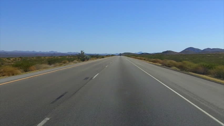 The point of view of someone driving a car on Interstate 40 through the Mojave