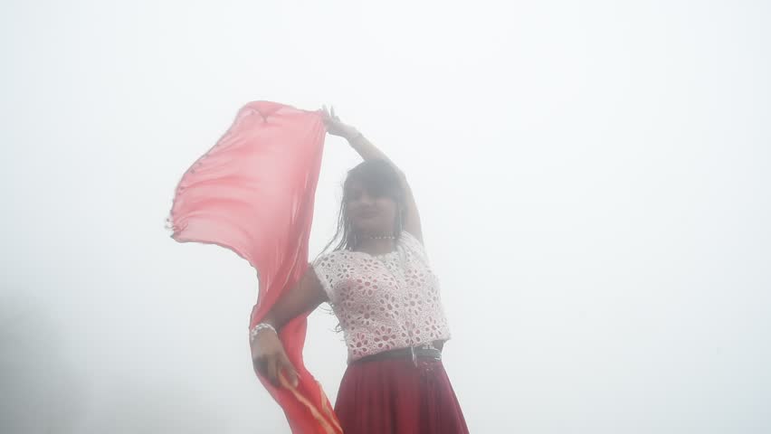 Happy Indian young girl in fog and enjoying nature.
