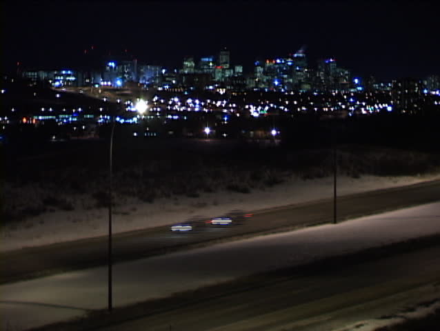 Night traffic on city boulevard with city skyline time lapse