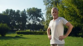 Dolly shot of a sporty aged man standing in the park