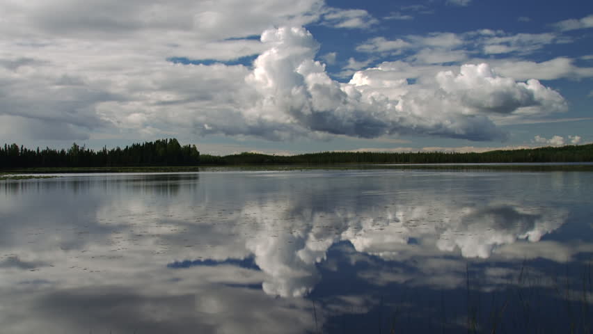 Expressive and dynamic cumulus storm clouds moving over an Alaskan lake on a