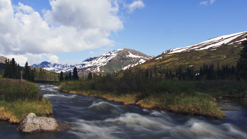 Alaskan scenic creek and mountains with clouds. Time lapse.