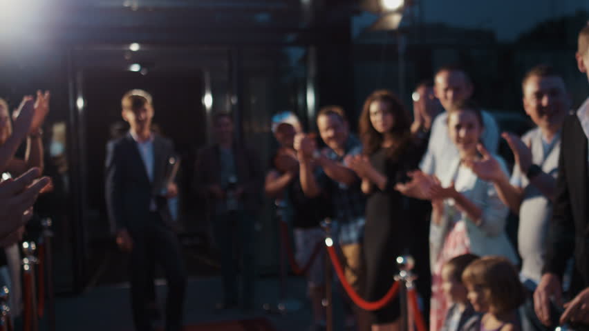 Award ceremony concept, young attractive bearded man in strict clothes trophy hands walking across red carpet crowd applause photo oscar press media flashes celebrating actors star handshake greetings | Shutterstock HD Video #31044712