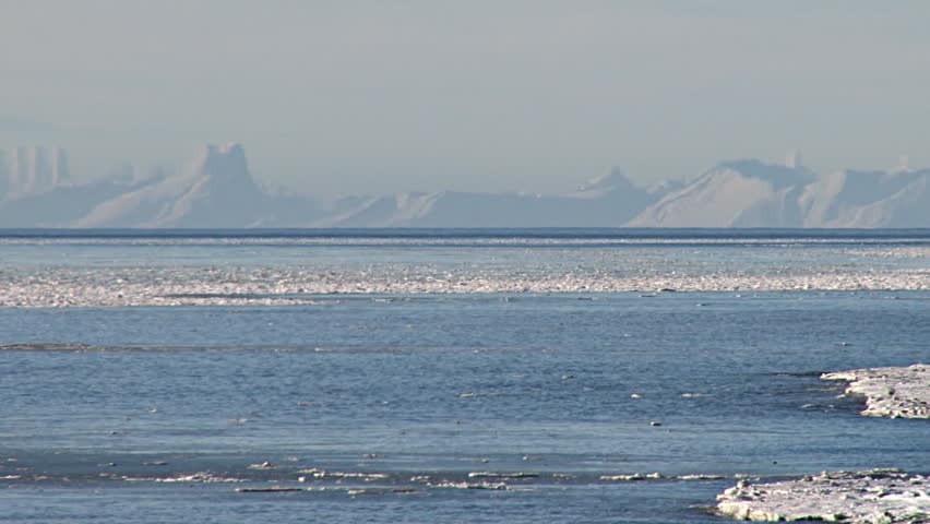 Long shot of the Aleutian Range across the icy Cook Inlet from Bishop's Beach in