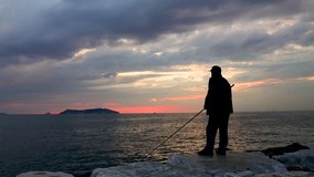 Island of Istanbul. Kinaliada, video sunset Istanbul, Turkey. Maltepe beach fishing man against Kinaliada.