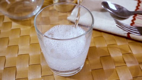 Mineral water pouring into a glass, the morning Breakfast, Slow motion with rotation tracking shot.