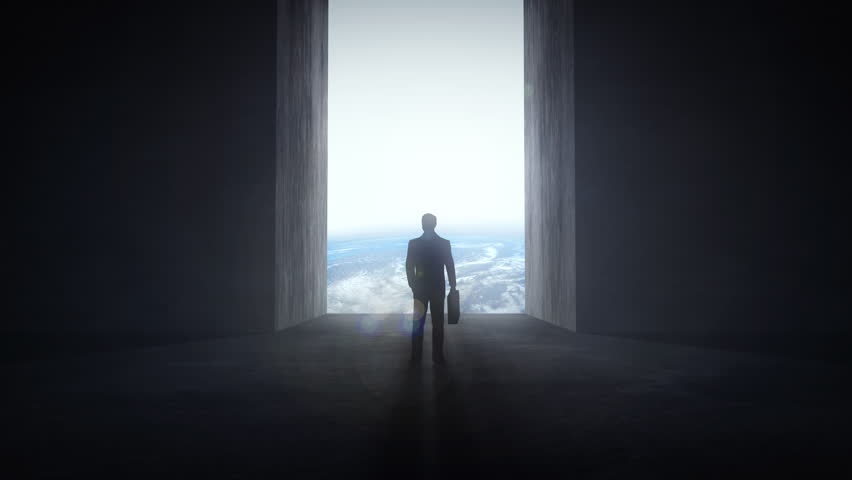 Businessman standing at an opening wall that reveals the Earth, motivation concept