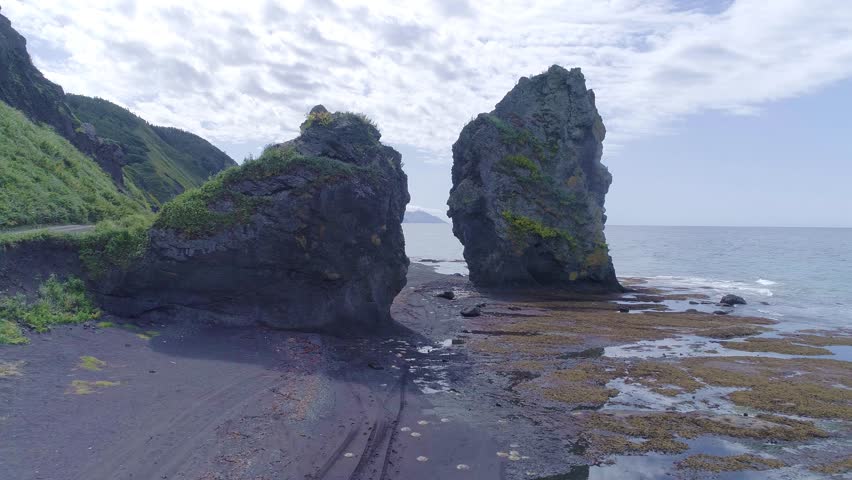 Flying over the big rock on sea background. 