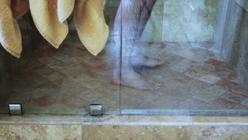 Man showering in luxury glass and tile shower