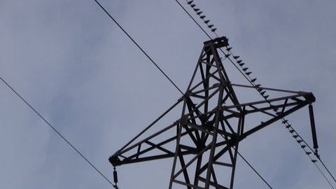 Panning shot of electric pylon with birds sitting on wire on blue sky background HD