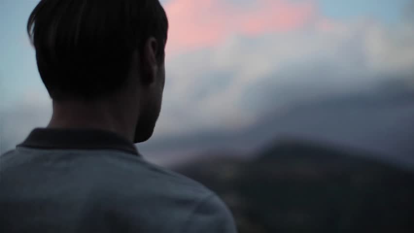 Man on mountain top looks down determined to conquer the world close up slow motion. Male head silhouette back side view at evening sky background enjoying view of success. Self-made person concept Royalty-Free Stock Footage #31079338
