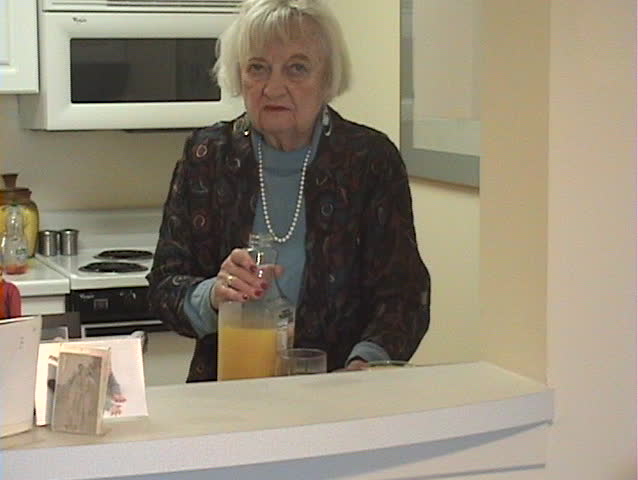 Senior Independent Women pouring and drinking Orange Juice