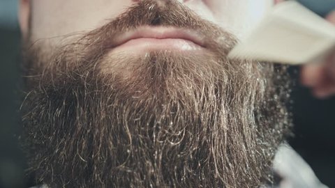 Man beard style. Close up of combing hair beard on face hipster. Bearded hipster face with moustache lips