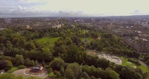 Aerial footage of Kelvingrove Park Low level reverse fly-over Kelvingrove Bandstand and skateboard park, with view of the Stewart Memorial Fountain.
