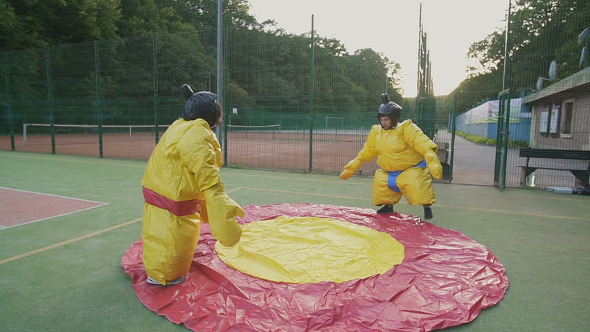 Young couple having fun on weekends. Playing in combat in sumo suits