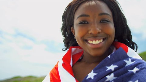 African American Beach Girl wrapped in American Flag. Slow motion.
