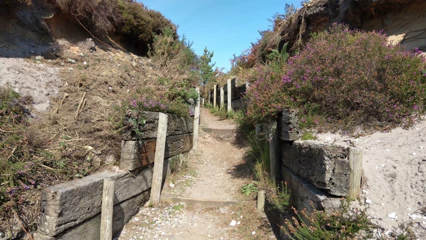 Through a World War I style trench. Leading to open heath land.