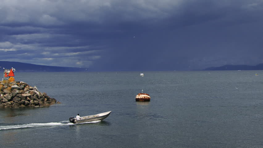 Man taking his skiff out for a spin on Kachemak Bay under sullen skies.